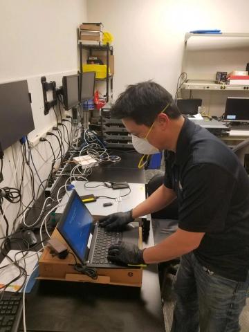 A NetEffect technician servicing a laptop at the workbench
