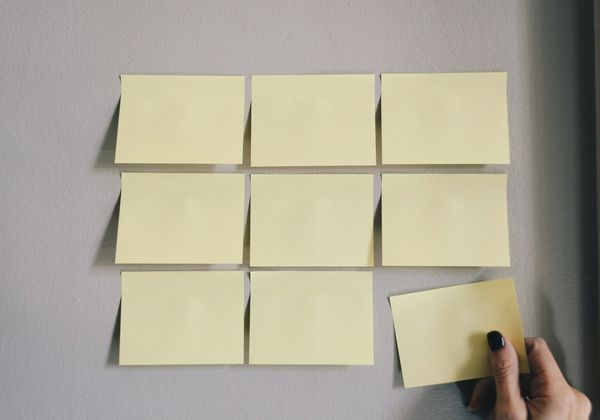 Blank sticky notes arranged in a grid on a wall
